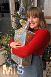 24.12.2019, Geschenke unter dem Weihnachtsbaum, in einem Wohnzimmer in Kaufbeuren. Stefanie freut sich ber ein Geschenk fr sie. Modelreleased