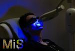 12.04.2024, FIBO-Messe fr Fitness, Wellness und Gesundheit in Kln. Ein Besucher lsst seine Zhne mittels blauem Licht bleichen.