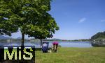 04.05.2023, Hopfensee in Bayern, Der Hopfensee bei Fssen im Allgu, Urlauber sitzen am See auf ihren Campingsthlen und geniessen die Aussicht.