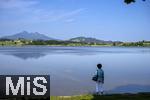 04.05.2023, Hopfensee in Bayern, Der Hopfensee bei Fssen im Allgu, Frau geniesst den Blick auf den See.