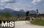 04.05.2023, Hopfensee in Bayern, Der Hopfensee bei Fssen im Allgu, Radfahrer an einer Brcke zum Wiesbauer-Gasthof.