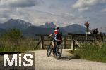 04.05.2023, Hopfensee in Bayern, Der Hopfensee bei Fssen im Allgu, Radfahrer an einer Brcke zum Wiesbauer-Gasthof.