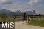 04.05.2023, Hopfensee in Bayern, Der Hopfensee bei Fssen im Allgu, Radfahrer an einer Brcke zum Wiesbauer-Gasthof.