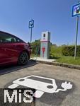 08.06.2023, Bad Wrishofen im Allgu, Ladesule fr E-Autos im Wohngebiet.  Ein Tesla Model 3 ldt gerade seinen Akku voll. Am Boden vom Parkplatz wurde das zugehrige Pictogramm angebracht.