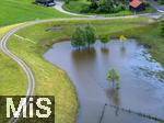02.06.2024, Kirchheim bei Bad Wrishofen im Unterallgu, Nach dem Hochwasser nach andauernden Regenfllen ist das Wasser ber Nacht zgig abgelaufen. Hier in dem berlaufbecken fr eine Jahrhunderflut vor dem Dorf steht nur noch wenig Stauwasser, Tags zuvor ist der Damm ungeplant bergelaufen und hat den Kirchdorfern teils katastrophale Wasserschden beschert. Luftbild mit Drohne