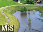 02.06.2024, Kirchheim bei Bad Wrishofen im Unterallgu, Nach dem Hochwasser nach andauernden Regenfllen ist das Wasser ber Nacht zgig abgelaufen. Hier in dem berlaufbecken fr eine Jahrhunderflut vor dem Dorf steht nur noch wenig Stauwasser, Tags zuvor ist der Damm ungeplant bergelaufen und hat den Kirchdorfern teils katastrophale Wasserschden beschert. Luftbild mit Drohne