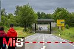 02.06.2024, Bad Woerishofen im Unterallgaeu, Hochwasser nach andauernden Regenfaellen, in der Unterfuehrung der Autobahn A96 zum Skylinepark bei Kirchdorf steht einen Tag nach dem Hochwasser noch der Grundwasserspiegel,  zwei Radfahrer fahren unerschrocken durch die Fluten, Passanten, auch Katastrophen-Touristen gennant, beobachten die Szene neugierig.