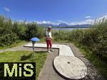 31.07.2023, Hopfensee in Bayern, Der Hopfensee bei Fssen im Allgu,  Minigiolfanlage direkt am See. Frau spielt Minigolf.