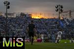 02.08.2024, Fussball 3. Liga 2024/2025, 1.Spieltag, TSV 1860 Mnchen - 1.FC Saarbrcken, im Stdtischen Stadion an der Grnwalderstrasse, Mnchen. Linienrichter an der Seitenlinie, hinter dem Stadion geht glutrot die Sonne unter.


