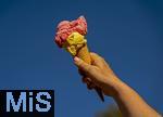 07.08.2024, Eistte mit Mango- und Himbeer-Eis aus einer Bad Wrishofener Eisdiele. Eine Frau streckt ihre Eistte in den blauen Himmel.