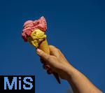 07.08.2024, Eistte mit Mango- und Himbeer-Eis aus einer Bad Wrishofener Eisdiele. Eine Frau streckt ihre Eistte in den blauen Himmel.