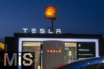 04.05.2025, Bayreuth, (Bayern), Die US-Firma Tesla hat hier einen Ladepark fr E-Autos an der Autobahn A9. An 20 modernen Schnell-Ladesulen knnen hier Teslafahrer und andere E-Auto-Fabrikate ihren Auto-Akku aufladen. Alle Stalls sind Supercharger Version V4. Die Wartezeit knnen sich die Autofahrer in einer Lounge der Firma bk-World vertreiben, mit Toiletten, Ruherume, Getrnke und Snack-Automaten und Sitzmglichkeiten etc.     Hinten ist eine Shell-Tankstelle.