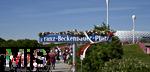 10.05.2025, Fussball 1. Bundesliga 2024/2025, 33. Spieltag, FC Bayern Mnchen - Borussia Mnchengladbach, in der Allianz-Arena Mnchen. Schild des frisch eingeweihten Franz-Becherbauer-Platzes vor dem Stadion, im Hintergrund strmen die Fans in die Arena

