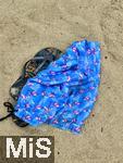 13.06.2024, Beliebtes Reiseziel der Deutschen, die Balearen-Insel Mallorca (Spanien).  Regenwetter am Strand Cala Agulla bei Cala Ratjada, Badelatschen und Badehose mit Flamingo-Aufdruck liegen im Sand. 