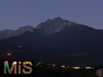 29.6.2025, Meran in Sdtirol, Italien. Herz-Jesu-Feuer auf dem Gebirgsgrat des Ifinger Berggipfel.
Der Brauch, im Juni Feuer zu entznden, geht auf frhere Sonnwend- bzw. Johannisfeuer zurck, welche in Erinnerung an das Herz-Jesu-Gelbnis von 1796 umgedeutet wurden. Unten leuchtet das Dorf Tirol in der Dmmerung.