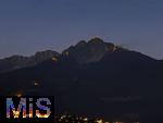 29.6.2025, Meran in Sdtirol, Italien. Herz-Jesu-Feuer auf dem Gebirgsgrat des Ifinger Berggipfel.
Der Brauch, im Juni Feuer zu entznden, geht auf frhere Sonnwend- bzw. Johannisfeuer zurck, welche in Erinnerung an das Herz-Jesu-Gelbnis von 1796 umgedeutet wurden. Unten leuchtet das Dorf Tirol in der Dmmerung.