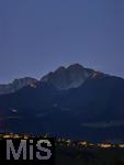 29.6.2025, Meran in Sdtirol, Italien. Herz-Jesu-Feuer auf dem Gebirgsgrat des Ifinger Berggipfel.
Der Brauch, im Juni Feuer zu entznden, geht auf frhere Sonnwend- bzw. Johannisfeuer zurck, welche in Erinnerung an das Herz-Jesu-Gelbnis von 1796 umgedeutet wurden. Unten leuchtet das Dorf Tirol in der Dmmerung.