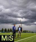07.07.2025, Fussball 1. Bundesliga 2025/2026, Trainingsauftakt FC Augsburg, am Trainingsplatz an der WWK-Arena Augsburg, Trainer Sandro Wagner (FC Augsburg) und Geschftsfhrer Michael Strll (FC Augsburg) vor der dunklen Wolkenwand eines Gewitters ber Augsburg und der Baustelle am Parkplatz der Arena.

