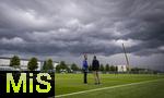 07.07.2025, Fussball 1. Bundesliga 2025/2026, Trainingsauftakt FC Augsburg, am Trainingsplatz an der WWK-Arena Augsburg, Trainer Sandro Wagner (FC Augsburg) und Geschftsfhrer Michael Strll (FC Augsburg) vor der dunklen Wolkenwand eines Gewitters ber Augsburg und der Baustelle am Parkplatz der Arena.


