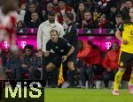 18.10.2025, Fussball Bundesliga 2025/2026, 7.Spieltag, FC Bayern Mnchen - Borussia Dortmund, in der Allianz-Arena Mnchen, Rene Rohde (Schiedsrichterassistent) konzentriert am Spielfeldrand, hinten: Trainer Vincent Kompany (FC Bayern Mnchen) diskutiert mit Daniel Schlager (Vierter Offizieller)
