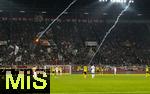 31.10.2025, Fussball 1. Bundesliga 2025/2026, 9.Spieltag, FC Augsburg - Borussia Dortmund, in der WWK-Arena Augsburg. Leuchtrakete, die die Dortmunder Fans abgebrannt haben, fliegt quer ber den Platz zu den Gstefans in den Augsburger Block. Auch die Spieler auf dem Platz Keven Schlotterbeck (FC Augsburg), Serhou Yadaly Guirassy (Borussia Dortmund), Iris Chrislain Aurel Matisma (FC Augsburg) beobachten eine Rakete die direkt neben den Spielern einschlgt.
