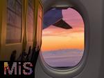 05.12.2025 Passagierflugzeug, Blick aus dem Fenster einer Ryanair-Maschine beim Anflug auf Memmingen im Abendrot, hinten sieht man die Alpenkette hinter Wolkenschwaden.